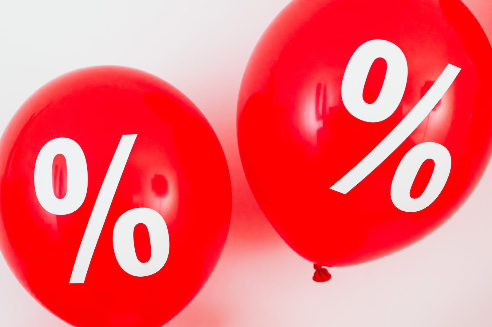 two red balloons with percentage symbols on white background