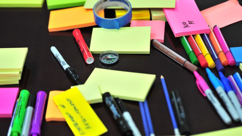 Sticky notes and pens on a table.